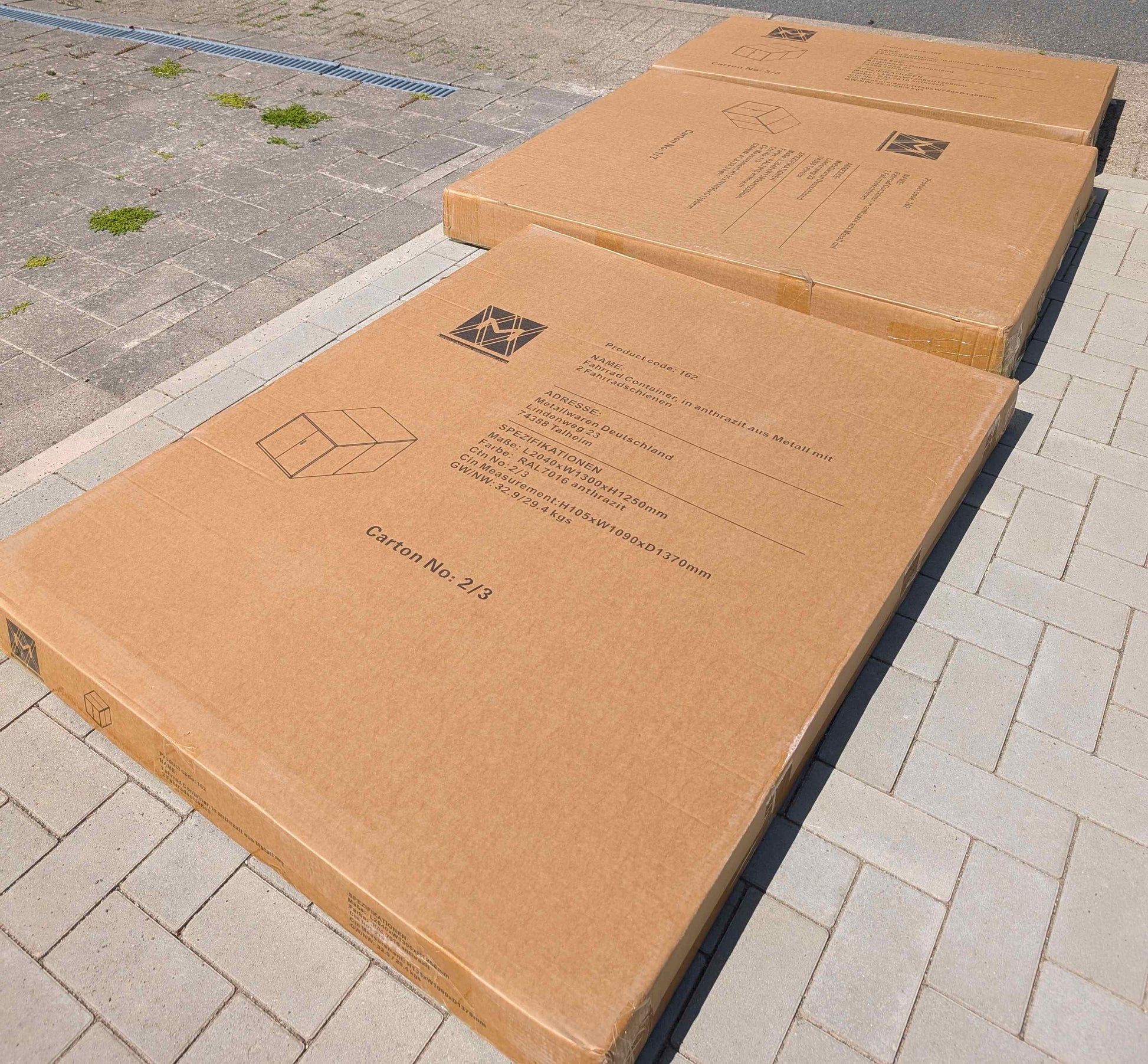 Anlieferzustand der Fahrradgarage E-Bike, zur Selbstmontage in drei festen Kartons am Aufbau-Ort liegend