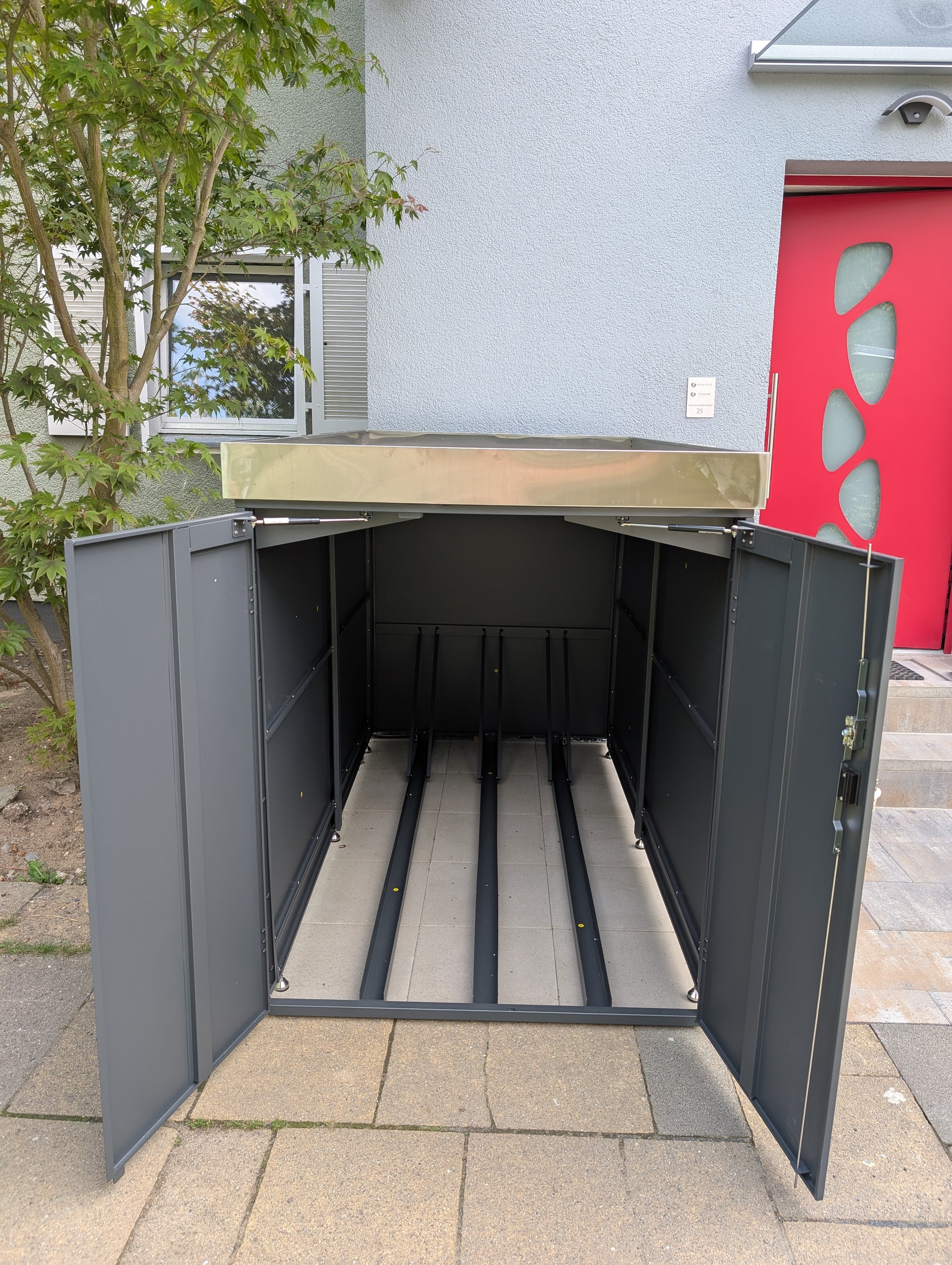 Innenansicht Fahrradgarage Metall anthrazit – mit drei Fahrradschienen, Vorderradhaltern und stabiler Doppeltür