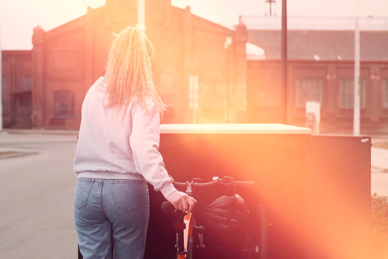 Frau schiebt Fahrrad in die 3er Fahrradgarage Statement