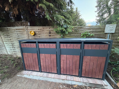 Moderne_Muelltonnenbox_4er_aus_Anthrazit_Metall_mit_Holzoptik_Fronten_und_aufklappbarem_Deckel_im_Aussenbereich